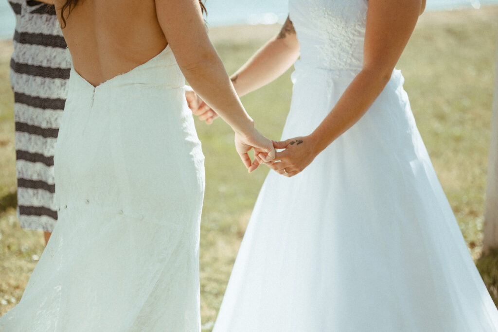 lesbian brides holding hands during wedding ceremony