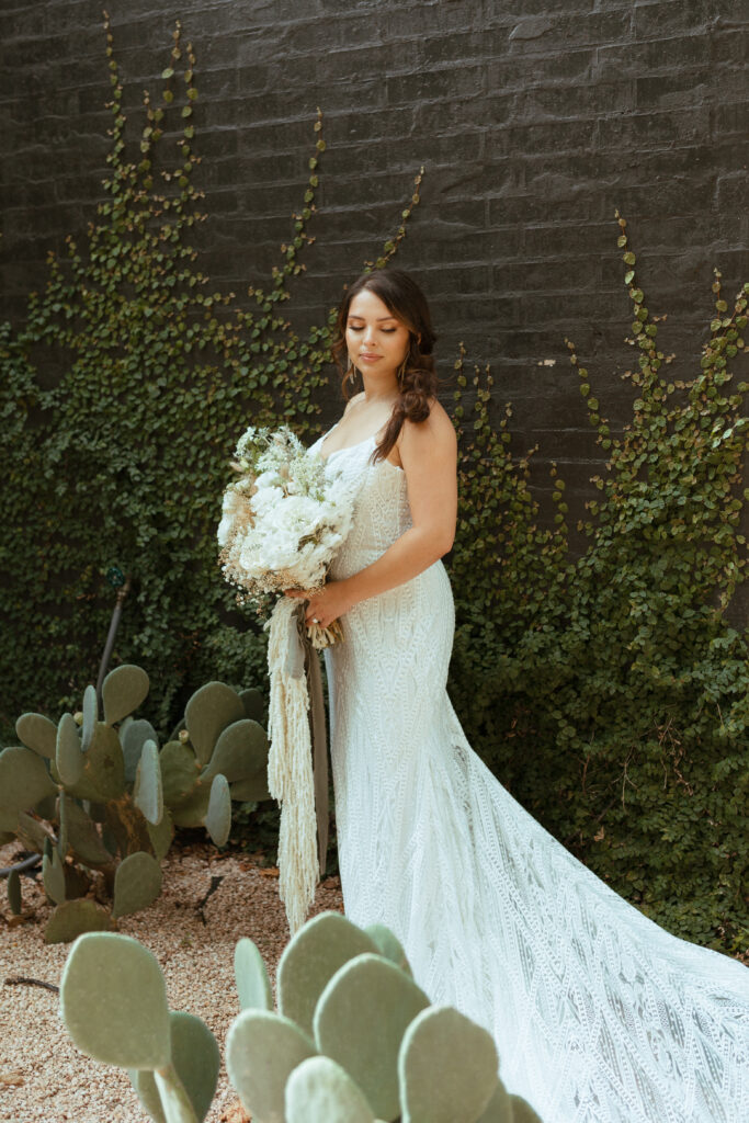 bridal portraits against a black brick wall with ivy and cactus