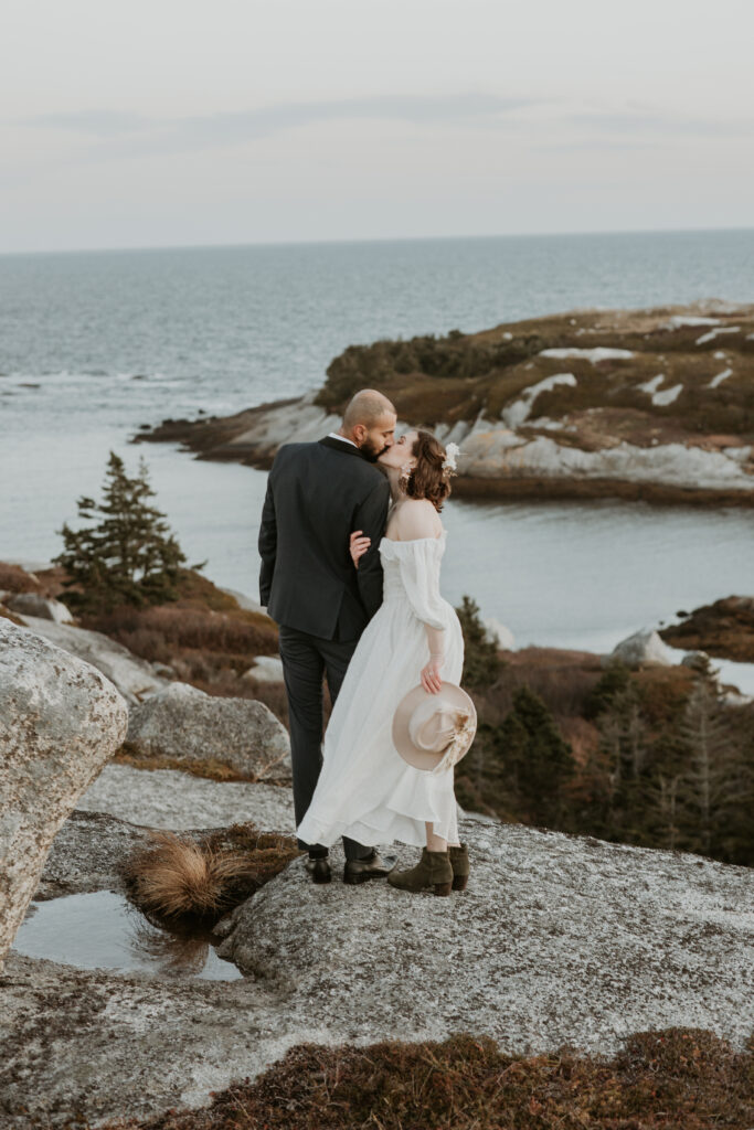 couple kissing amongst rugged shoreline in nova scotia