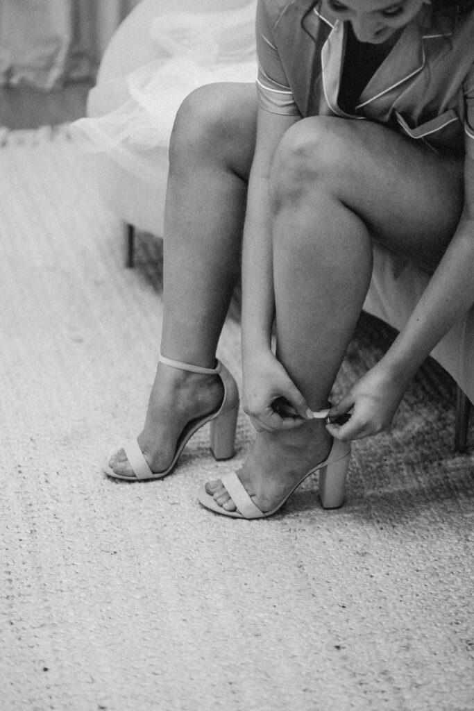 bride adjusting her heels while getting ready