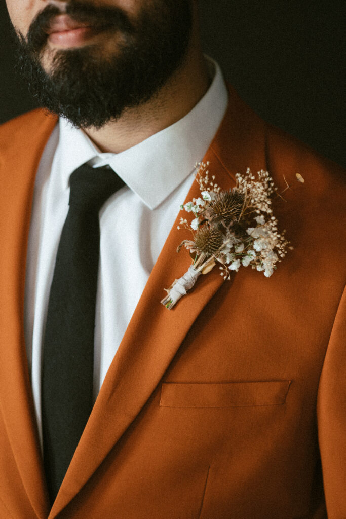 groom's neutral dried floral boutonniere and autumn inspired suit