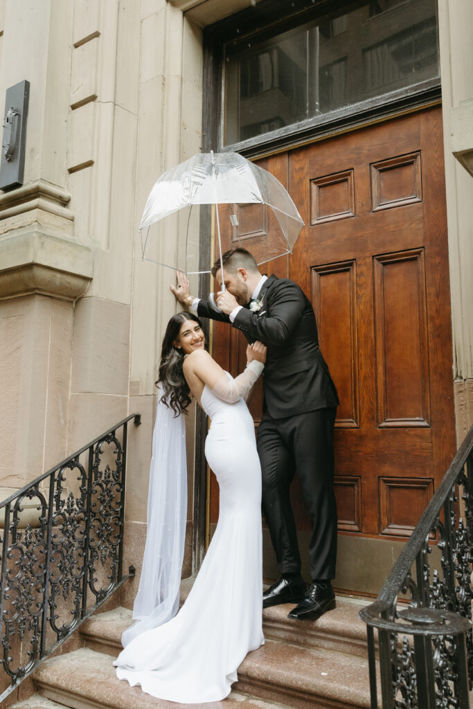 Bride and groom portraits on rainy day in downtown Halifax featuring an umbrella infront of The Halifax Club